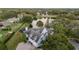 Stunning aerial view of home with screened pool, lush landscaping, and a picturesque lake with fountain feature at 2523 Madron Ct, Orlando, FL 32806