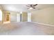 Large carpeted bedroom featuring neutral walls, a ceiling fan, and multiple entry doors at 2523 Madron Ct, Orlando, FL 32806