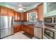Warm kitchen featuring wood cabinetry, stainless steel appliances, and plenty of counter space at 2523 Madron Ct, Orlando, FL 32806