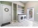 Functional laundry room with washer, dryer, shelving, and access to the outdoors at 2523 Madron Ct, Orlando, FL 32806