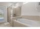 Bright bathroom featuring a soaking tub and a separate glass-enclosed shower at 3955 Lana Ave, Davenport, FL 33897
