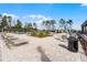 Community pool area with lounge chairs, tables, umbrellas, and a view of the surrounding trees at 314 Rover Rd, Ormond Beach, FL 32174