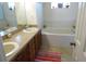 Bathroom with double sinks, wood cabinets, large mirror, and separate bathtub at 721 Willow Run St, Minneola, FL 34715