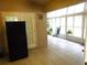 Bright sun room featuring ceramic tiles, windows, plants, and a refrigerator at 721 Willow Run St, Minneola, FL 34715