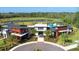 Aerial view of the clubhouse, a pool and green space, surrounded by a lush, green tree line at 17608 Saw Palmetto Ave, Clermont, FL 34714