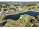 Aerial view of a golf course community with lake and clubhouse at 36711 Alaqua Ct, Eustis, FL 32736