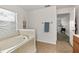 Bathroom featuring a garden tub with tile surround and a view into the next room at 36711 Alaqua Ct, Eustis, FL 32736