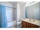 Bright bathroom features a tub with shower, vanity, and modern fixtures at 36711 Alaqua Ct, Eustis, FL 32736