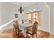 Dining room with hardwood floors, large window, and wooden table and chairs at 36711 Alaqua Ct, Eustis, FL 32736