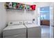 Laundry room with a set of appliances, storage shelf and view to the kitchen at 36711 Alaqua Ct, Eustis, FL 32736