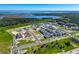 Aerial view of a new community development near a lake, featuring houses and open green spaces at 438 Belmond Dr, Debary, FL 32713