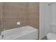 Simple bathroom with a tub, neutral tile, and toilet at 438 Belmond Dr, Debary, FL 32713