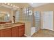 Elegant bathroom with a glass block shower, granite countertops, and wood cabinets at 4538 Nottoway Dr, Leesburg, FL 34748