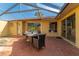 The covered patio features brick flooring, a dining table, and a view of the home's back exterior at 4916 Fiji Cir # 11, Orlando, FL 32808