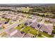 Aerial view of a residential area with solar panels, well-manicured lawns, and neighborhood streets at 1518 Alligator St, St Cloud, FL 34771