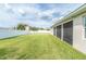 Expansive backyard with lush green grass, enclosed lanai, and white vinyl fence at 1518 Alligator St, St Cloud, FL 34771