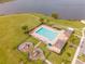 Community pool area with lounge chairs, umbrellas, playground, and a view of the lake at 1518 Alligator St, St Cloud, FL 34771