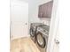 Modern laundry room with wood-look tile flooring and sleek gray appliances, offering both functionality and style at 1518 Alligator St, St Cloud, FL 34771
