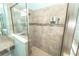 The tiled shower features a glass door, showerhead, and convenient shelving for toiletries at 1518 Alligator St, St Cloud, FL 34771