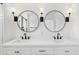 Modern bathroom featuring double vanities, round mirrors, sleek black fixtures, and sconces at 2171 E South St # 5, Orlando, FL 32803
