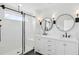 Modern bathroom featuring double vanities, round mirrors, sleek black fixtures, and a glass-enclosed shower at 2171 E South St # 5, Orlando, FL 32803