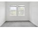 Bright bedroom featuring gray carpet, base trim, and two windows to provide natural light at 2171 E South St # 5, Orlando, FL 32803