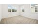 Bright bedroom featuring neutral carpet, multiple windows, and white walls and trim at 259 Severn Way # 38, Orlando, FL 32803