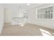 Bright bonus room with neutral carpet, white walls, windows and staircase with black railing at 259 Severn Way # 38, Orlando, FL 32803