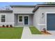 Charming home featuring a blue front door, manicured lawn, and fresh landscaping at 494 Marion Oaks Trl, Ocala, FL 34473