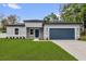 Beautiful home showcasing a manicured lawn, blue garage door, and modern exterior at 494 Marion Oaks Trl, Ocala, FL 34473