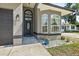 Close up of front entry featuring an arched doorway, decorated glass, exterior lighting, and lush landscaping at 535 Madison Ave, Daytona Beach, FL 32114