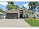 Lovely gray single-story home featuring an attached two-car garage, large windows, and well-maintained landscaping at 535 Madison Ave, Daytona Beach, FL 32114