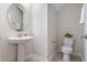 Elegant half bathroom with pedestal sink, decorative mirror, and white fixtures at 11357 Satire St, Orlando, FL 32832