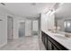 Bright bathroom with double vanity, sleek dark cabinets, and decorative lighting at 11357 Satire St, Orlando, FL 32832