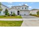 Charming two-story home features a two-car garage, manicured lawn, and well-maintained landscaping at 11357 Satire St, Orlando, FL 32832