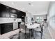 Eat-in kitchen features modern black cabinetry, stainless steel appliances and a dining table at 11357 Satire St, Orlando, FL 32832