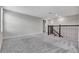 Spacious upstairs hallway with gray carpeting and a modern black railing at 11357 Satire St, Orlando, FL 32832