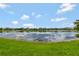 Scenic community pond with beautiful reflections of the sky and surrounding homes at 11357 Satire St, Orlando, FL 32832