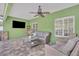 Covered lanai with a ceiling fan, neutral colored wicker seating, and a mounted TV at 3136 Heartleaf Pl, Winter Park, FL 32792