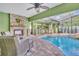 Outdoor kitchen with brick fireplace and seating area located next to the pool and enclosed lanai at 3136 Heartleaf Pl, Winter Park, FL 32792