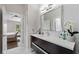Modern bathroom features a sleek vanity with a white countertop, a large mirror, and plenty of natural light at 8704 Crestgate Cir, Orlando, FL 32819