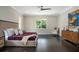 Comfortable bedroom with hardwood floors, a large window, stylish furniture, and tasteful decor at 8704 Crestgate Cir, Orlando, FL 32819