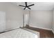 Minimalist bedroom with hardwood floors, a ceiling fan, and access to an ensuite bathroom at 8704 Crestgate Cir, Orlando, FL 32819
