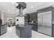 Modern kitchen features gray cabinets, stainless steel appliances, an island with granite countertop, and white marble tile floors at 8704 Crestgate Cir, Orlando, FL 32819