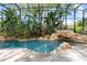 Enclosed pool with rock waterfall feature and lush tropical landscaping at 8704 Crestgate Cir, Orlando, FL 32819