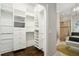 This walk-in closet features custom shelves and drawers, with an adjacent bathroom that has a glass-enclosed shower at 8704 Crestgate Cir, Orlando, FL 32819