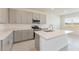 Modern kitchen featuring sleek grey cabinets, stainless steel appliances, and a quartz countertop island at 3106 Windswept, Wildwood, FL 34785