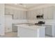 Modern kitchen featuring gray cabinets, an island with a sink, and stainless steel appliances at 3106 Windswept, Wildwood, FL 34785