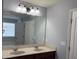 Bathroom featuring double sinks with dark wood cabinets and large mirror at 3612 Julius Estates Blvd, Winter Haven, FL 33881