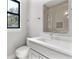 Modern bathroom featuring white vanity with gray cabinets, a large mirror, and tiled shower with glass doors at 1904 Illinois St, Orlando, FL 32803